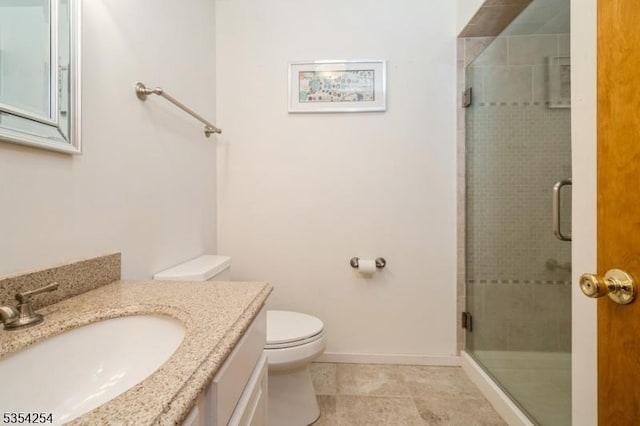 bathroom with vanity, toilet, baseboards, tile patterned floors, and a shower stall