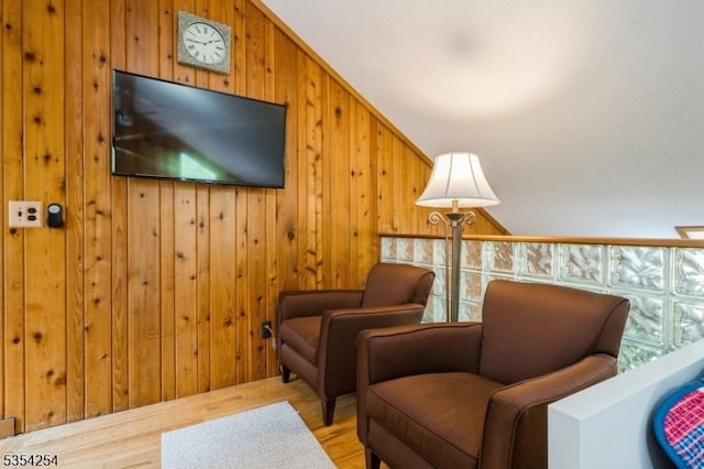 living area with wood walls and wood finished floors