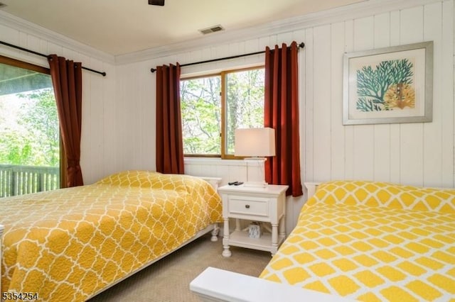 carpeted bedroom with access to outside, visible vents, and ornamental molding