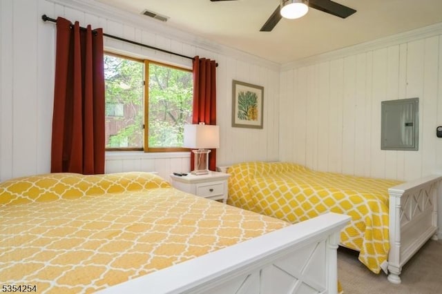 carpeted bedroom with crown molding, a ceiling fan, visible vents, and electric panel