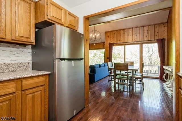 kitchen featuring freestanding refrigerator, dark wood finished floors, backsplash, and a healthy amount of sunlight