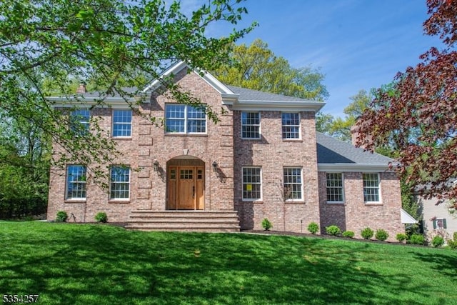 view of front of property with brick siding and a front yard