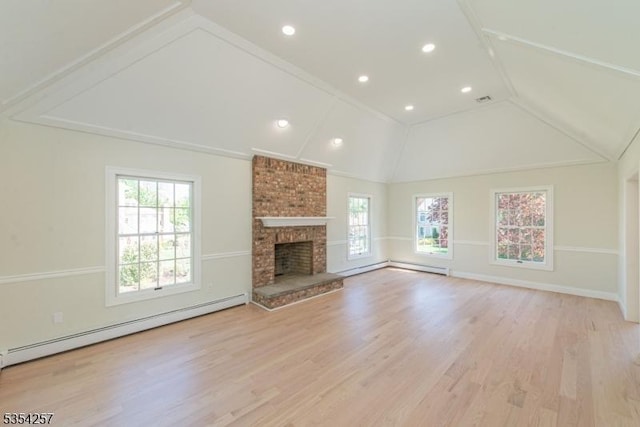 unfurnished living room featuring a baseboard heating unit, a healthy amount of sunlight, lofted ceiling, and a fireplace