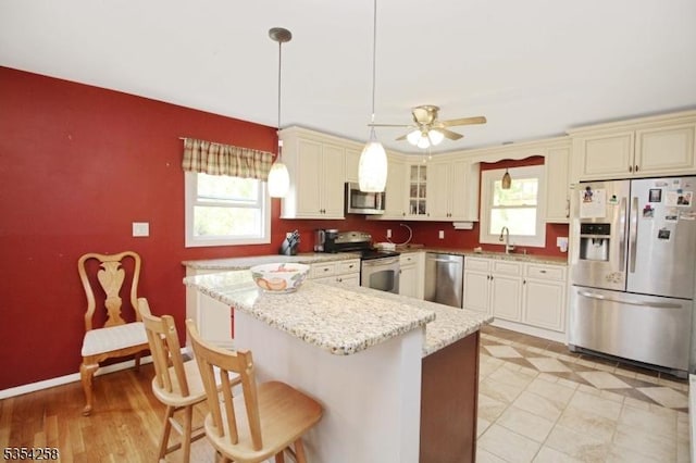 kitchen featuring plenty of natural light, a sink, a ceiling fan, and stainless steel appliances