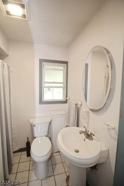 bathroom featuring a sink, tile patterned flooring, toilet, and visible vents