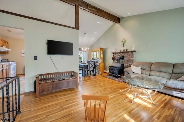 12 Fox Ledge Dr, Vernon Twp, NJ 07418 - living area with a notable chandelier, a wood stove, light wood-style flooring, baseboards, and vaulted ceiling with beams