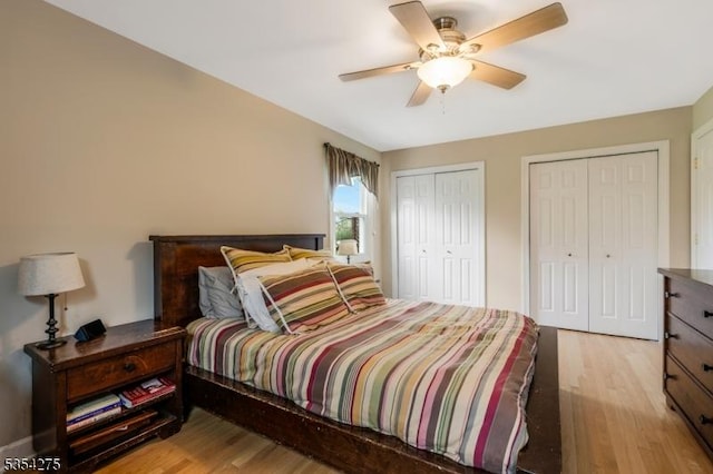 bedroom with ceiling fan, multiple closets, and light wood-type flooring