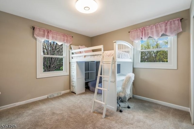 carpeted bedroom with baseboards, multiple windows, and visible vents