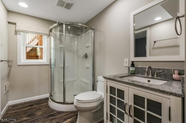 full bath with vanity, toilet, wood finished floors, visible vents, and a stall shower
