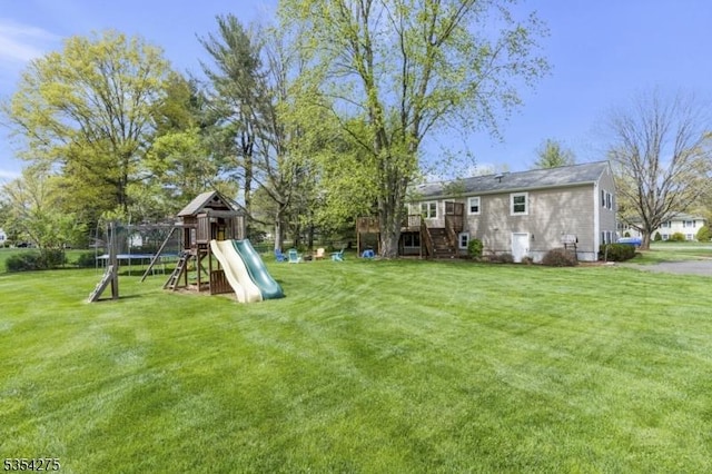 view of yard with a wooden deck, stairs, and a playground
