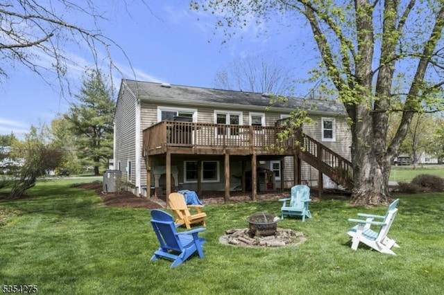 back of house with stairway, a fire pit, a yard, and a deck