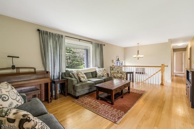 living room with light wood-style flooring and a notable chandelier