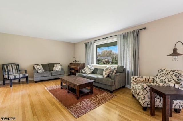 living area with baseboards and light wood finished floors