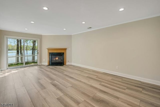 unfurnished living room featuring light wood-style floors, baseboards, crown molding, and recessed lighting