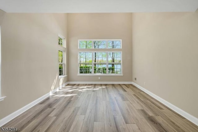 unfurnished room with baseboards and wood finished floors