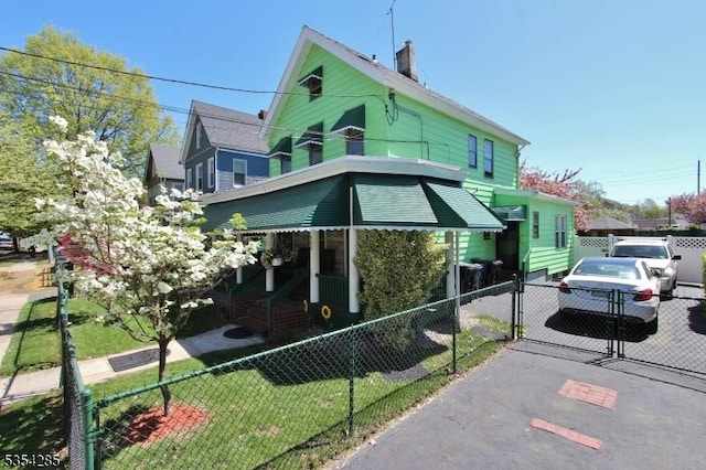 view of front of house with fence private yard, a gate, and a chimney