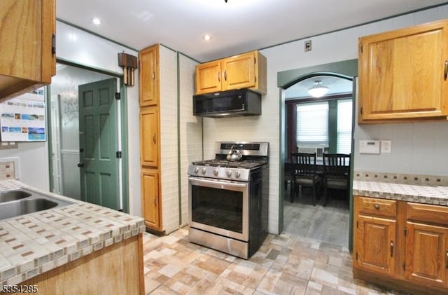 kitchen featuring black microwave, light floors, recessed lighting, stainless steel range with gas stovetop, and a sink