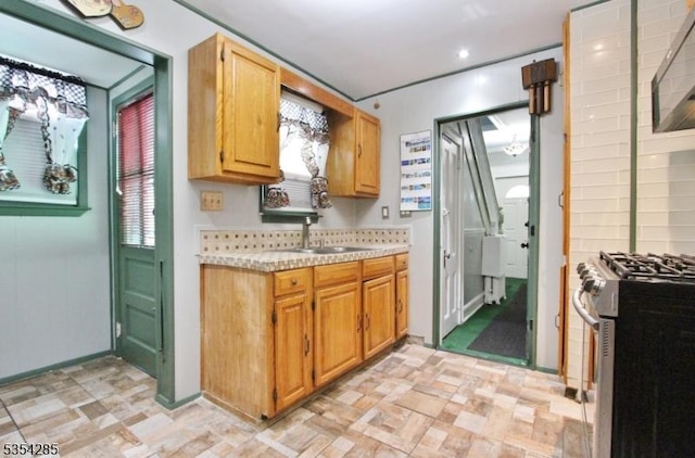 kitchen featuring light countertops, recessed lighting, a sink, and stainless steel gas stove
