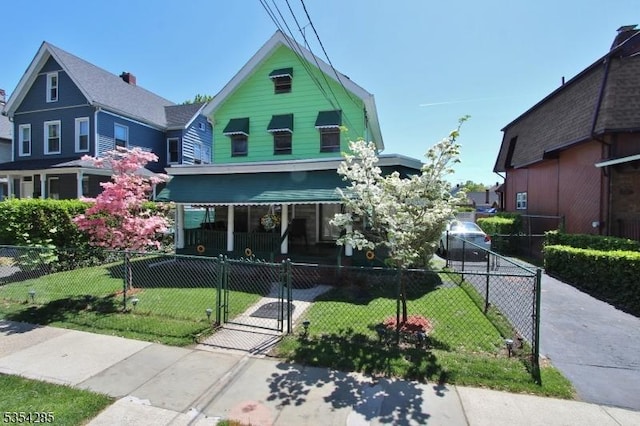 victorian home with a porch, a gate, a fenced front yard, and a front yard