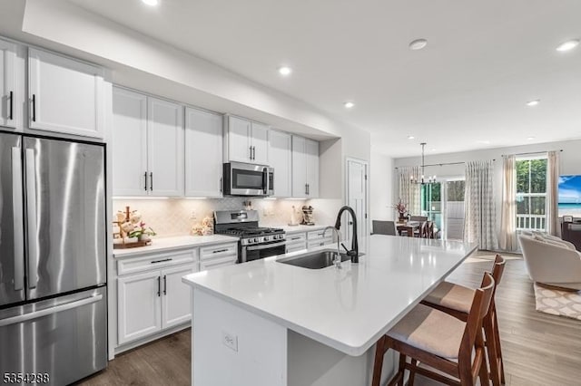 kitchen featuring a sink, light countertops, stainless steel appliances, recessed lighting, and dark wood-type flooring