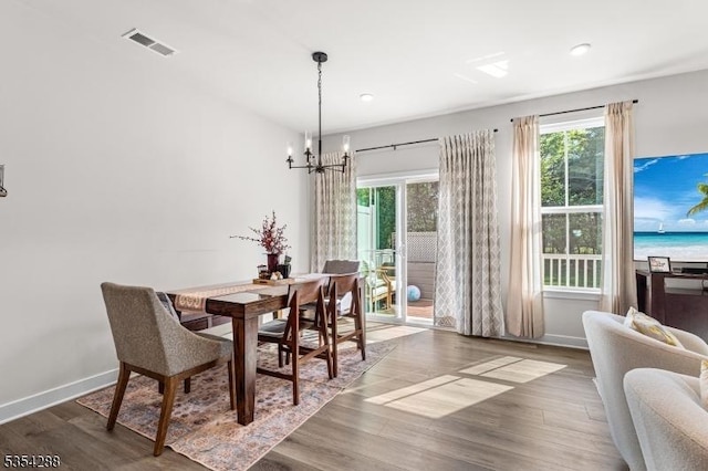 dining room with an inviting chandelier, recessed lighting, baseboards, wood finished floors, and visible vents