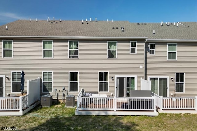 rear view of property with a deck and cooling unit