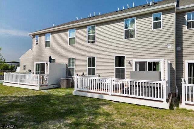 rear view of house featuring a lawn, a wooden deck, and central air condition unit