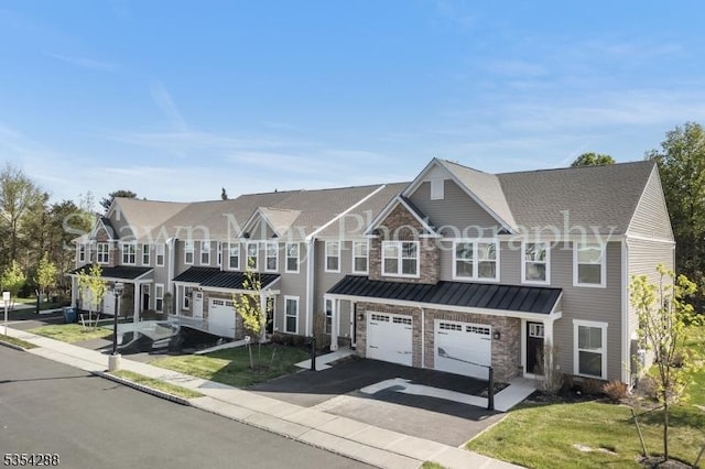 townhome / multi-family property with metal roof, a garage, driveway, and a standing seam roof