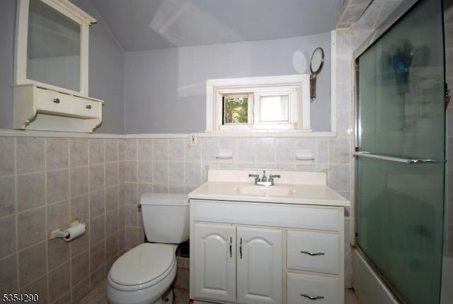 29 Olcott St, Franklin Twp, NJ 08873 - full bathroom with wainscoting, vanity, toilet, tile walls, and bath / shower combo with glass door