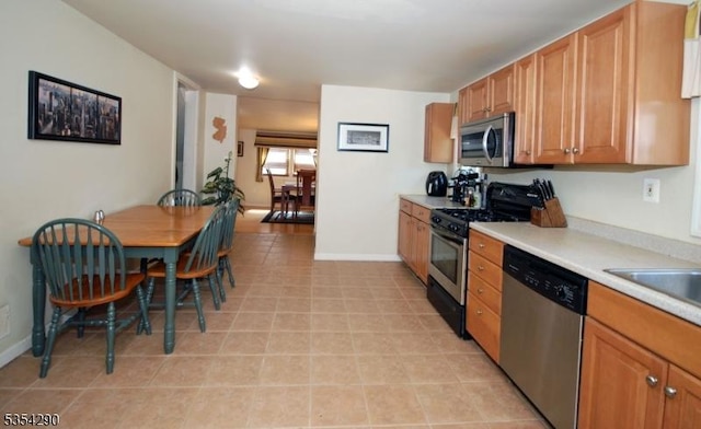 29 Olcott St, Franklin Twp, NJ 08873 - kitchen with brown cabinets, a sink, light countertops, stainless steel appliances, and baseboards