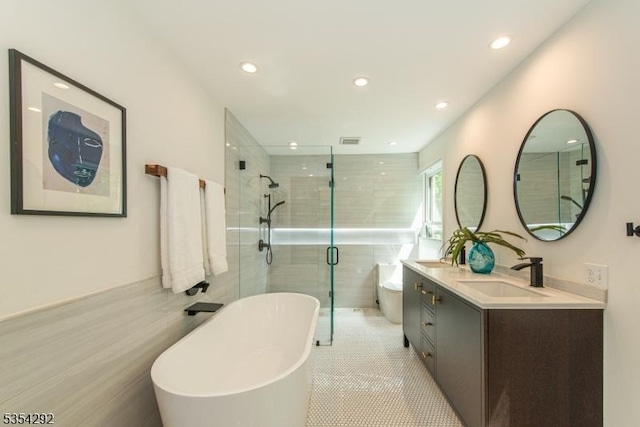 full bathroom with a sink, a freestanding tub, recessed lighting, and double vanity