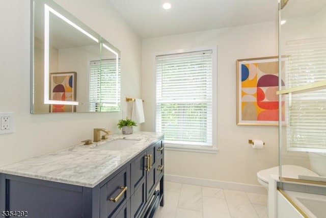 full bath featuring baseboards, plenty of natural light, vanity, and marble finish floor