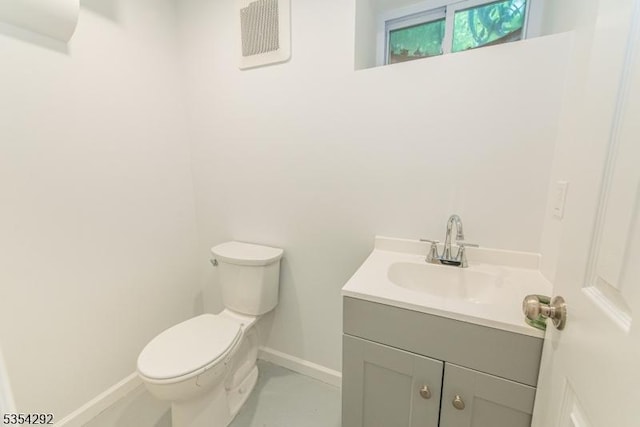 half bathroom with vanity, baseboards, visible vents, and toilet