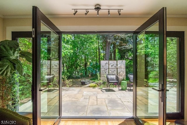 doorway to outside featuring crown molding and stone finish flooring
