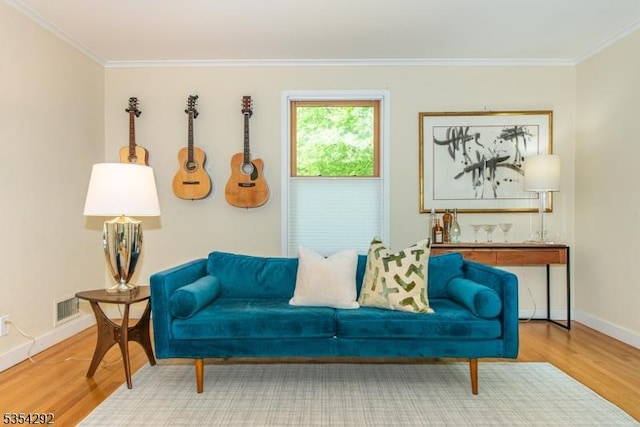 living area with baseboards, ornamental molding, and wood finished floors