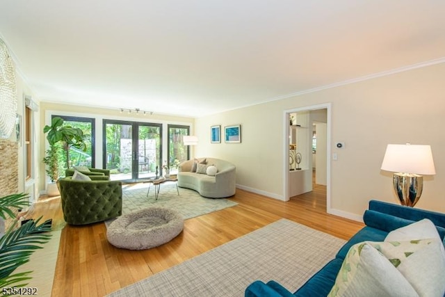 living area with crown molding, baseboards, and wood finished floors