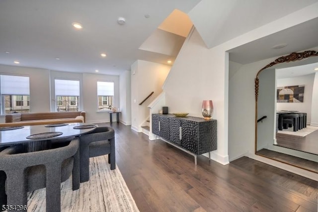 dining area with recessed lighting, baseboards, wood finished floors, and stairway