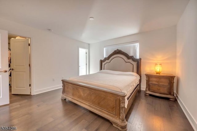 bedroom featuring baseboards and dark wood-style floors