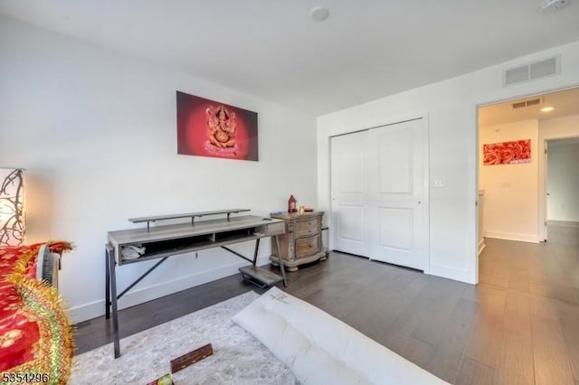 bedroom with visible vents, baseboards, and wood finished floors
