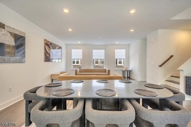 dining room with recessed lighting, baseboards, wood finished floors, and stairway