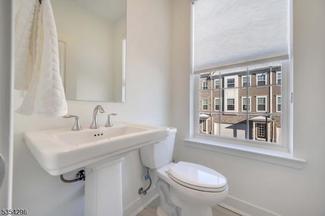 bathroom featuring toilet and baseboards