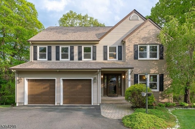 view of front of house with an attached garage and asphalt driveway