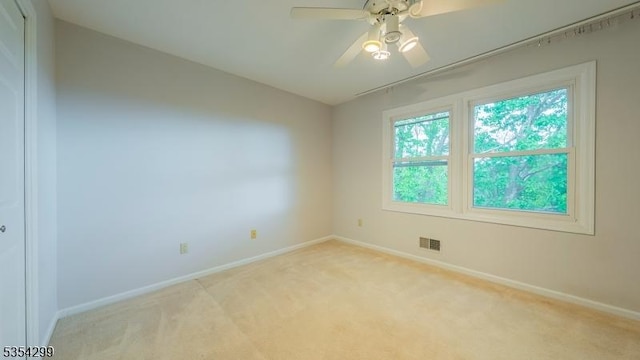 unfurnished room with baseboards and light colored carpet