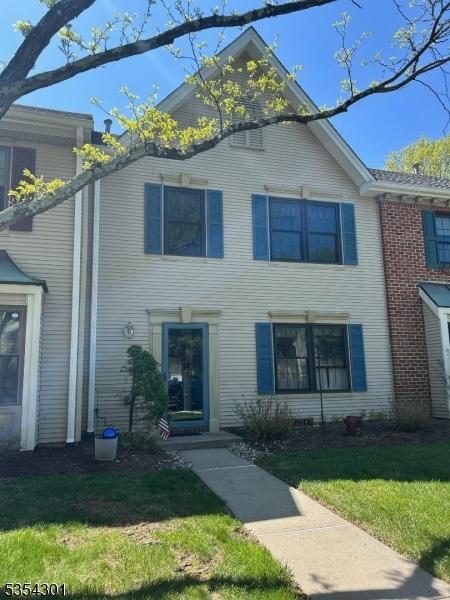 townhome / multi-family property featuring a front lawn