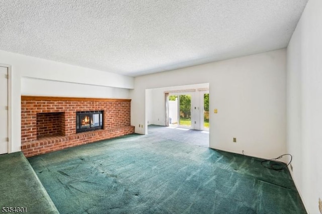 unfurnished living room with carpet, a fireplace, a textured ceiling, and french doors