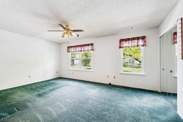 carpeted spare room with ceiling fan and a textured ceiling
