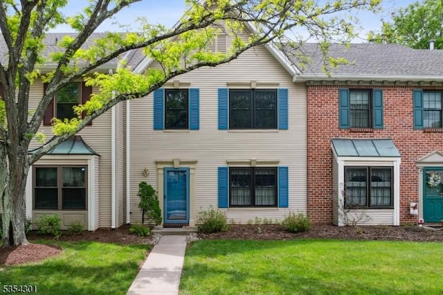 townhome / multi-family property featuring a front lawn