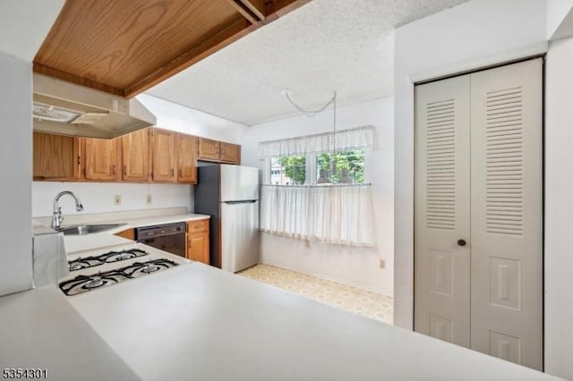 kitchen with freestanding refrigerator, a sink, black dishwasher, light countertops, and brown cabinets