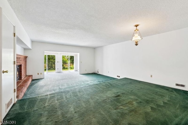 unfurnished living room with french doors, carpet, a brick fireplace, and a textured ceiling