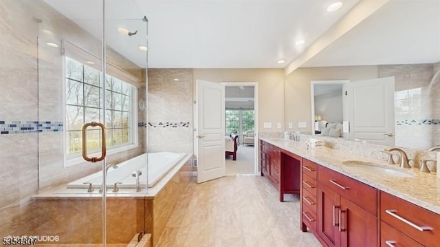 full bath featuring double vanity, a garden tub, ensuite bath, a sink, and recessed lighting